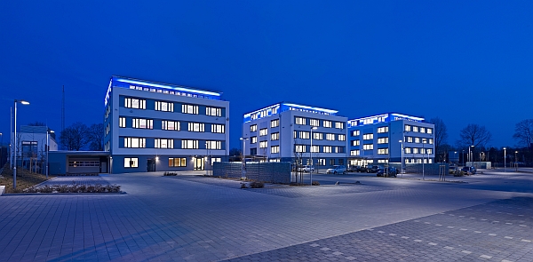 Am heutigen Dienstag wurde der neue Standort der Volksbank Mittelhessen, das FinanzWerk im Wetzlarer Gewerbepark Spilburg, offiziell in Betrieb genommen. Wetzlars Oberbürgermeister Wolfram Dette und Vorstandssprecher Dr. Peter Hanker übergaben das Gebäude seiner Bestimmung.338 Mitarbeiterinnen und Mitarbeiter Deutschlands drittgrößter Volksbank haben nun in dem modernen Komplex ihren Arbeitplatz. Drei baugleiche Einheiten mit jeweils vier Geschossen beherbergen rund zehn verschiedene Bereiche wie die Organisation und IT, den DirektService oder verschiedene Marktserviceabteilungen. Mehrheitlich finden sich hier Abteilungen ohne Kundenkontakt, also Teile der so genannten Produktionsbank. Der Name „FinanzWerk“ soll diesem Umstand Rechnung tragen. Mit der Bündelung der Back-Office-Tätigkeiten will die Volksbank Mittelhessen Abstimmungs- und Entscheidungswege verkürzen und so Synergien heben.Zur Eröffnungszeremonie erschienen heute rund 100 geladene Gäste, darunter die Investoren, der Generalunternehmer Martin Bender von der Bauunternehmung Weimer GmbH, Handwerker, Vertreter der Presse, außerdem zahlreiche Führungskräfte und Mitarbeiter der Volksbank Mittelhessen. Oberbürgermeister Dette enthüllte nach seiner Ansprache feierlich das neu geschaffene Logo des FinanzWerks Wetzlar. Nach den Ansprachen hatten die Gäste Gelegenheit für einen Rundgang durch die neuen Büros. Anschließend lud die Volksbank zu einem Sektempfang und Imbiss.„Mit dieser Investition stärkt die Volksbank Mittelhessen den Standort Wetzlar und gibt der lokalen Wirtschaft wertvolle Impulse“, betonte Oberbürgermeister Dette. Vorstandssprecher Dr. Peter Hanker ergänzte: „Hier in Wetzlar fanden wir optimale Rahmenbedingungen für den neuen Sitz. Die Zentralisierung der Back-Office-Tätigkeiten ist für uns ein wichtiger Schritt zur Steigerung der eigenen Effizienz.“ Am 20.01.2010 erfolgte der erste Spatenstich, schon im März konnte der Grundstein gelegt werden. Nach knapp über einem Jahr bis zur Fertigstellung summieren sich die Baukosten auf 18,8 Millionen Euro. Die Aufträge wurden dabei an heimische Unternehmen vergeben. Im Februar dieses Jahres bezogen die ersten Abteilungen der Bank die neuen Räumlichkeiten.Die Gebäude stehen auf einem 13.600 m² großen Grundstück, auf welchem sich vormals die Kleiderkammern der Bundeswehr befanden. Insgesamt umfasst der vom Gießener Architekturbüro Feldmann geplante Komplex einen umbauten Raum von 34.000 m³ und 2.633 m² Bürofläche. Die Volksbank Mittelhessen mietet die Gebäude über zwanzig Jahre und verfügt über eine Verlängerungsoption von zwei mal fünf Jahren.(Quelle: Volksbank Mittelhessen)